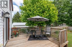 Expansive wood-finish decking featuring a perimeter railing and direct access to the exterior via a white-framed door - 
