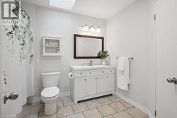 Bathroom featuring a white vanity with a light-toned countertop, a framed mirror, and a three-light fixture - 