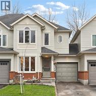 Cream siding exterior with a prominent arched window and a single-car garage - 