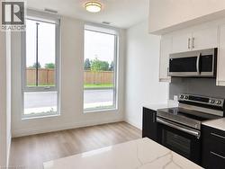 Contemporary kitchen featuring two-tone cabinetry, stainless steel appliances, and a quartz countertop island - 