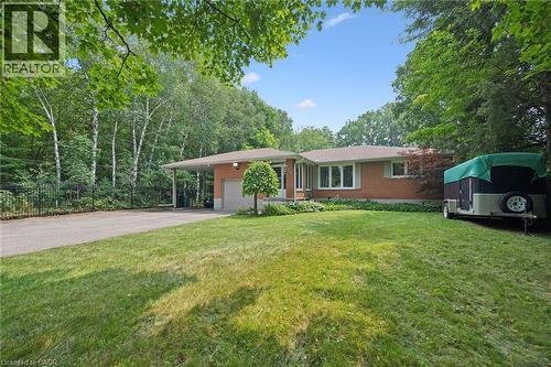 Brick-clad residence featuring a front lawn, paved driveway, and mature perimeter trees, featuring a spacious front lawn with irrigation. - 410 Avenue Road, Cambridge, ON - Outdoor