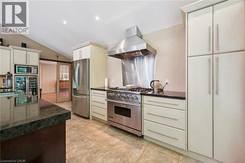 Gourmet kitchen featuring a stainless steel range with a professional-grade hood, dark stone countertops, tile flooring, and light-toned cabinetry with long bar pulls, featuring a Viking natural gas c - 410 Avenue Road, Cambridge, ON - Indoor Photo Showing Kitchen