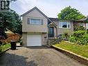 Split-level residence featuring a brick and vertical siding exterior, an attached garage with a panel door, and a dedicated driveway - 67 Pinemeadow Crescent, Waterloo, ON  - Outdoor 