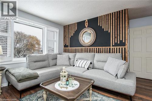 Living area featuring a prominent accent wall with vertical wood paneling and a dark painted background - 67 Pinemeadow Crescent, Waterloo, ON - Indoor Photo Showing Living Room