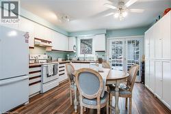 Kitchen featuring white cabinetry, wood-finish flooring, and light blue wall tones - 
