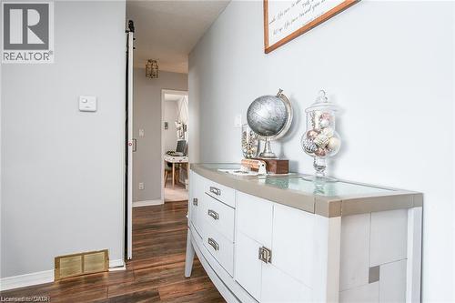 Hallway featuring wood-finish flooring, a contemporary white dresser with a light-toned top, and a sliding barn-style door - 67 Pinemeadow Crescent, Waterloo, ON - Indoor Photo Showing Bathroom