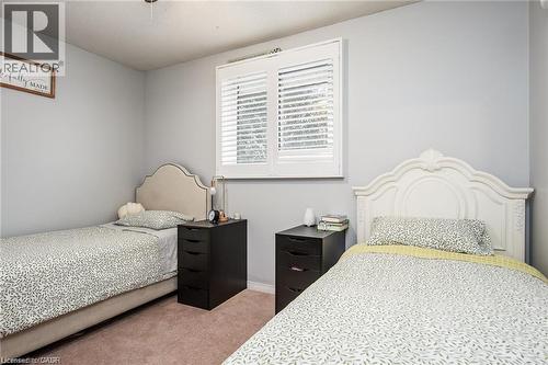 Room with light gray walls, plush carpeting, and a window fitted with white plantation shutters - 67 Pinemeadow Crescent, Waterloo, ON - Indoor Photo Showing Bedroom