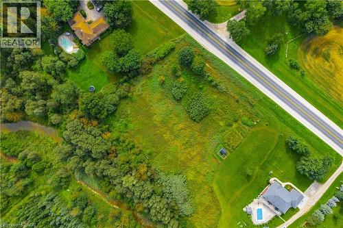 Expansive property featuring a paved road frontage, extensive green space, a winding creek, and mature tree lines - 7916 Wellington Road 109, Arthur, ON 