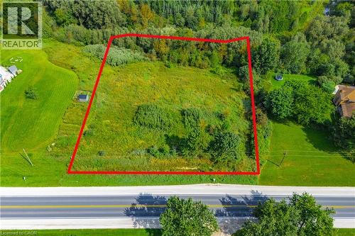 Expansive land parcel featuring a mix of cleared and treed areas, bordered by a paved road - 7916 Wellington Road 109, Arthur, ON 