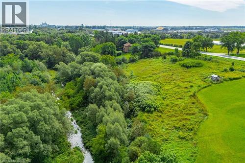 Expansive green landscape featuring mature trees and a natural watercourse - 7916 Wellington Road 109, Arthur, ON 