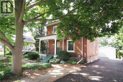 Brick residence with a covered front porch featuring white columns and black railings - 148 Tiffany Street, Cambridge, ON - Outdoor