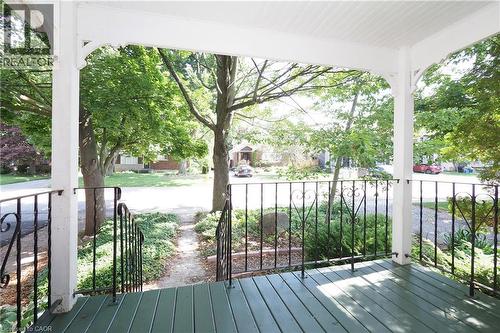 Covered front porch featuring a tongue-and-groove ceiling, decorative white columns, painted wood-plank flooring, and ornate wrought-iron railings - 148 Tiffany Street, Cambridge, ON - Outdoor With Deck Patio Veranda