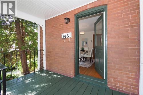 Brick exterior with a covered porch featuring a painted wood floor and black metal railings - 148 Tiffany Street, Cambridge, ON - Outdoor With Exterior