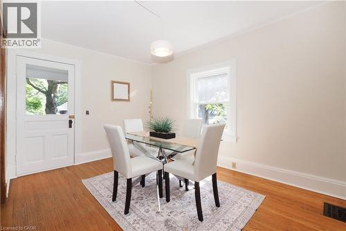 Room featuring wood-finish flooring, a white paneled door with glass insert, and a double-hung window - 148 Tiffany Street, Cambridge, ON - Indoor Photo Showing Dining Room