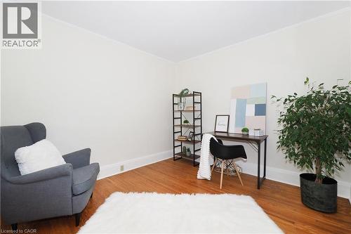 Hardwood flooring provides a warm foundation for this versatile space, featuring neutral wall tones and white trim - 148 Tiffany Street, Cambridge, ON - Indoor