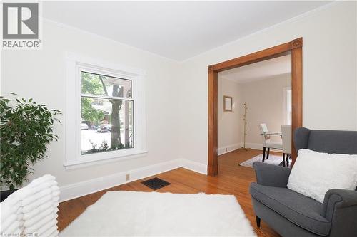Hardwood flooring throughout, featuring a cased opening with wood trim, a single window with white trim, and white baseboards - 148 Tiffany Street, Cambridge, ON - Indoor