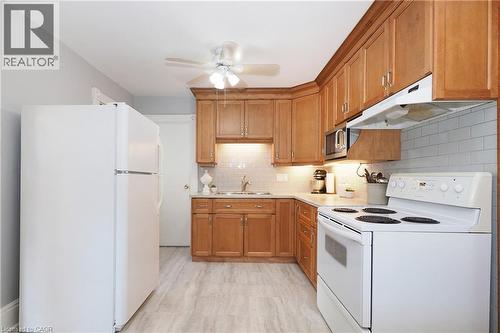 Kitchen featuring light wood cabinetry, white subway tile backsplash, light-toned countertops, and wood-finish flooring - 148 Tiffany Street, Cambridge, ON - Indoor Photo Showing Kitchen
