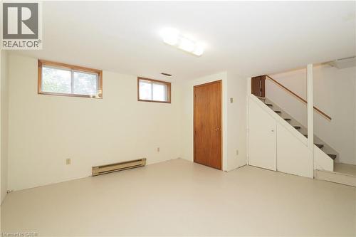 Finished lower level with neutral flooring, two windows, and integrated baseboard heating - 148 Tiffany Street, Cambridge, ON - Indoor Photo Showing Other Room