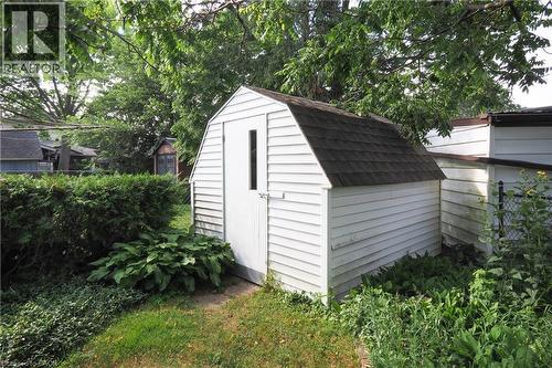 White garden shed with gambrel roof, shingle roofing, and vertical window - 148 Tiffany Street, Cambridge, ON - Outdoor
