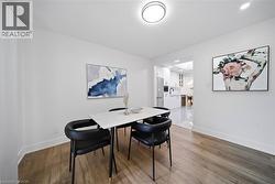 Dining area featuring wood-finish flooring, white walls, and a recessed ceiling light - 
