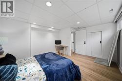 Spacious room featuring wood-finish flooring, recessed lighting, and a white drop-ceiling - 