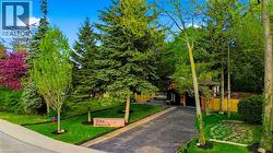 Private drive with mature landscaping and established tree coverage - 