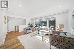 Living area featuring a large picture window, recessed lighting, crown molding, and wood-finish flooring - 