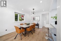 Dining area featuring wood-finish flooring, recessed lighting, and a modern sputnik chandelier - 
