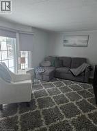 Living area featuring light gray wall paint, white trim, and a textured white ceiling - 