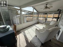 Sunroom featuring expansive windows, wood-finish flooring, a vaulted ceiling, and a ceiling fan - 