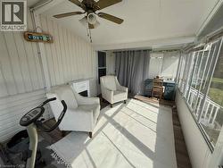 Sunroom with wood-finish flooring, a ceiling fan, and large window panels - 