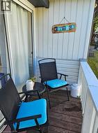 Outdoor balcony space featuring wood-finish flooring and white vertical siding - 