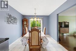 Dining area featuring a central chandelier, light blue walls, and tile flooring - 