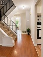Elegant stair case leading to the upper level with neutral carpeting and modern black railings - 