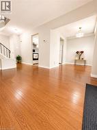 Bright and spacious open-concept living room with beautiful hardwood flooring and abundant natural light - 