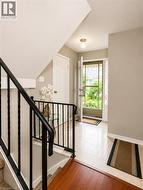 Entry foyer featuring light-toned tile flooring, a solid core entry door, and an overhead flush-mount light fixture - 