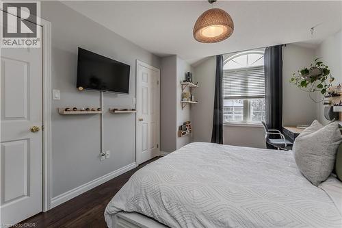 Arch-top window with horizontal blinds and dark drapery panels - 2121 Prospect Street, Burlington, ON - Indoor Photo Showing Bedroom