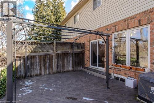 Expansive outdoor deck featuring a dark wood-finish surface, a metal pergola structure, and a sliding glass door entry to the interior - 2121 Prospect Street, Burlington, ON - Outdoor With Deck Patio Veranda With Exterior