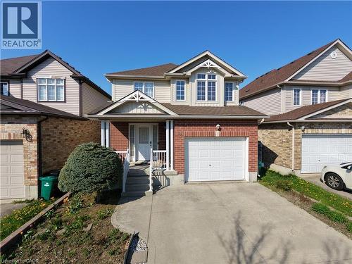 Two-story residence featuring a brick and siding exterior, an attached single-car garage, and a covered front porch with white columns - 28 Lemon Grass Street, Kitchener, ON - Outdoor With Facade