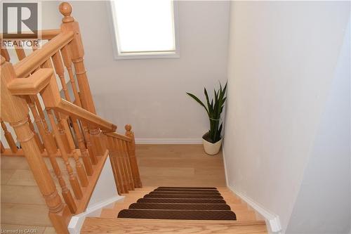Staircase featuring wood-finish treads and risers, complemented by a natural wood banister and balusters - 28 Lemon Grass Street, Kitchener, ON - Indoor Photo Showing Other Room