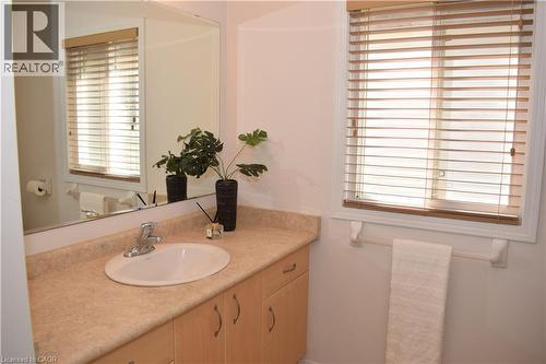 Bathroom vanity featuring a light-toned countertop, undermount sink, and wood-finish cabinetry - 28 Lemon Grass Street, Kitchener, ON - Indoor Photo Showing Bathroom