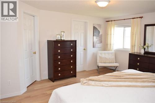Bright room featuring wood-finish flooring, a double-paned window with curtain rod, and white trim - 28 Lemon Grass Street, Kitchener, ON - Indoor Photo Showing Bedroom