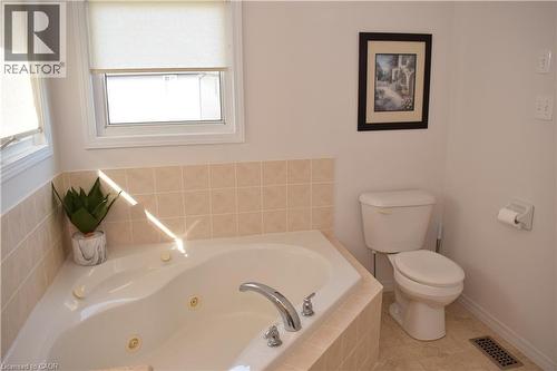Corner soaking tub with integrated jets and chrome fixtures - 28 Lemon Grass Street, Kitchener, ON - Indoor Photo Showing Bathroom