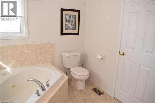 Corner soaking tub with chrome fixtures and light-toned tile surround - 28 Lemon Grass Street, Kitchener, ON - Indoor Photo Showing Bathroom