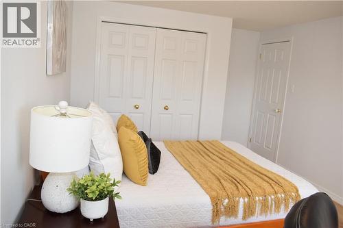 Bedroom featuring light gray walls, white baseboards, and two paneled doors with brass hardware - 28 Lemon Grass Street, Kitchener, ON - Indoor Photo Showing Bedroom