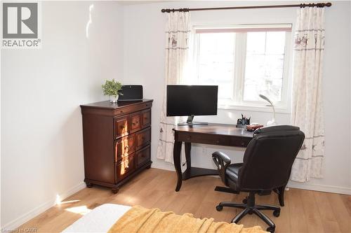 Bright interior space featuring a window with white trim, wood-finish flooring, and white walls - 28 Lemon Grass Street, Kitchener, ON - Indoor Photo Showing Office