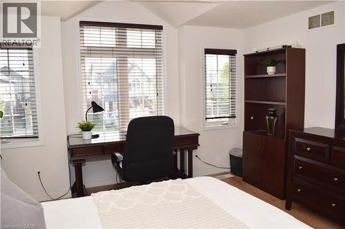 Bright room featuring three windows with horizontal blinds and light wood-finish flooring - 28 Lemon Grass Street, Kitchener, ON - Indoor