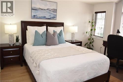 Bedroom featuring wood-finish flooring, white walls, and a window with blinds - 28 Lemon Grass Street, Kitchener, ON - Indoor Photo Showing Bedroom