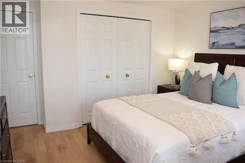 Bedroom featuring wood-finish flooring, white paneled bifold closet doors, and white paneled interior doors - 28 Lemon Grass Street, Kitchener, ON - Indoor Photo Showing Bedroom