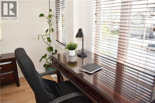 Bright interior space featuring wood-finish flooring, a window with horizontal blinds, and a built-in wood desk - 28 Lemon Grass Street, Kitchener, ON - Indoor Photo Showing Office